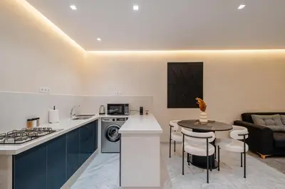 a kitchen and living room with a stove and a table at Modernite et Bien Etre au Coeur de la Ville in Marrakech