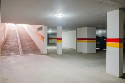an empty parking garage with red yellow and white columns at Sejour lumineux et moderne dans le centre de Marrakech in Marrakech
