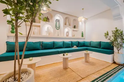 a living room with a blue couch and two tables at Riad Imrani - piscine - 6 mn from Jamaa Al Fna in Marrakech