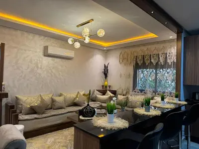 a living room with a couch and a table at Duplex chic et lumineux avec piscine proche centre in Marrakech
