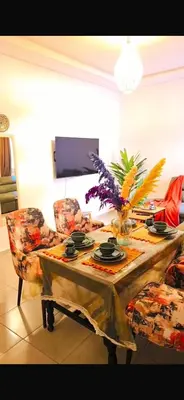 a table in a living room with a table and chairs at Appartement a 5 min de l aeroport de marrakech in Marrakech