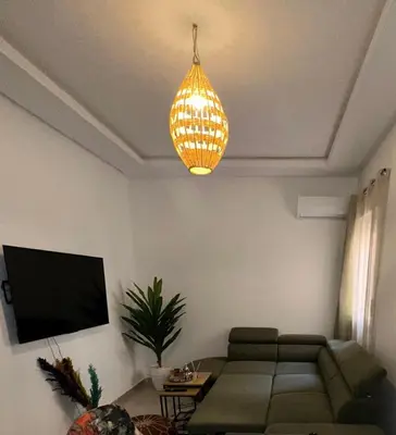 a living room with a couch and a chandelier at Appartement a 5 min de l aeroport de marrakech in Marrakech