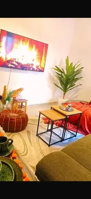 a living room with a table and a fireplace at Appartement a 5 min de l aeroport de marrakech in Marrakech