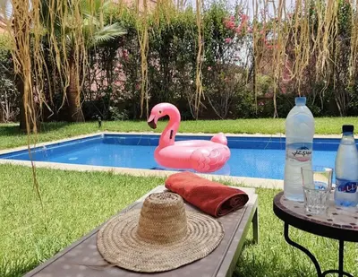 a pink flamingo float sitting next to a pool at Villa Dar Ouladi - Marrakech - Pool & Rooftop in Marrakech