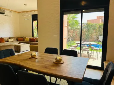 a dining room with a table and a living room at Villa Dar Ouladi - Marrakech - Pool & Rooftop in Marrakech