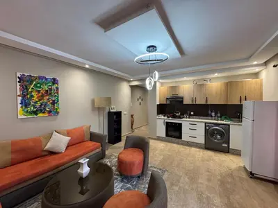 a living room with a couch and a kitchen at Opera 3 in Marrakech