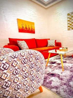 a living room with a red couch and a purple rug at Lilia apartment marrakech in Marrakech