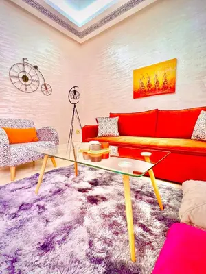 a living room with a red couch and a purple rug at Lilia apartment marrakech in Marrakech