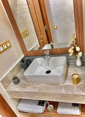 a white sink in a bathroom with a mirror at Lilia apartment marrakech in Marrakech