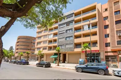 a street with cars parked in front of a building at Gueliz Harmony in Marrakech