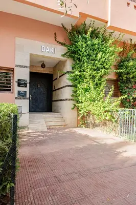 a building with a black door and a brick sidewalk at Propre et bien situé avec parking sous-sol etWi-Fi in Marrakech
