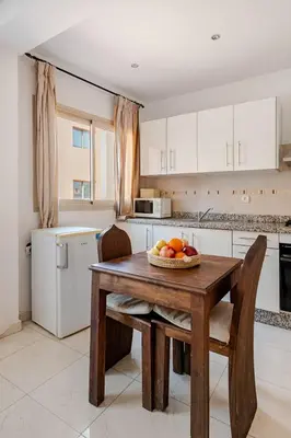 a kitchen with a table with a bowl of fruit on it at Propre et bien situé avec parking sous-sol etWi-Fi in Marrakech