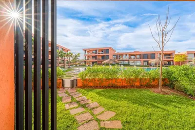 a view of a yard with buildings in the background at Appartement moderne et spacieux avec terrasse et piscine au Noria Golf in Marrakech