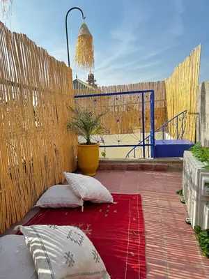 a patio with two pillows on a red blanket at Riad LK25 in Marrakech