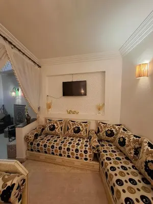 a living room with a couch and a flat screen tv at Riad LK25 in Marrakech