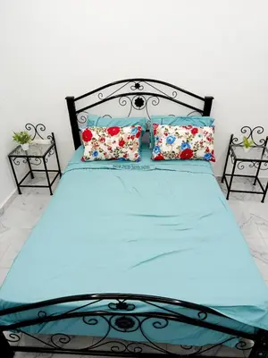 a bedroom with a bed with blue sheets and pillows at Stylish Moroccan Apartment in Marrakech