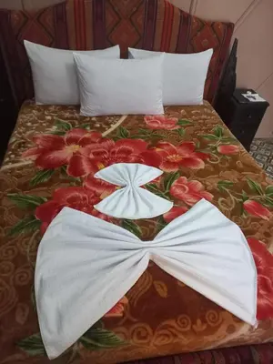 a bed with white sheets and red flowers on it at Breeze home in Marrakech