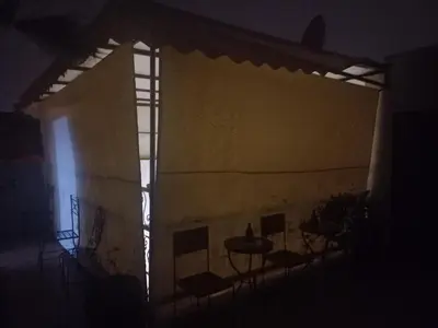 a dark room with chairs and a table and a window at Breeze home in Marrakech