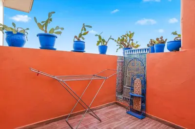 a shopping cart on a balcony with potted plants at Charmant appartement avec terrasse au cœur de Marrakech in Marrakech