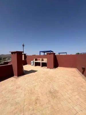 a patio with a table on top of a building at Appartement de charme au Vizir Resort in Dar Caïd Layadi