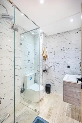 a bathroom with a glass shower and a toilet at Atlas Light Heart of Gueliz & Parking in Marrakech
