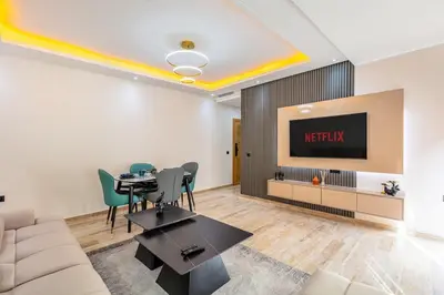 a living room with a table and a tv at Atlas Light Heart of Gueliz & Parking in Marrakech