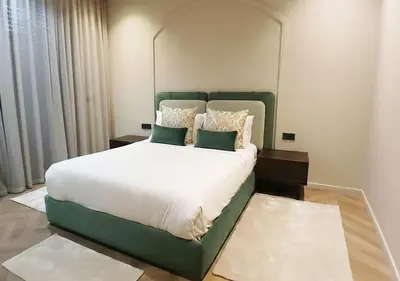 a bedroom with a large bed with a green headboard at Villa Soleil Couchant in Marrakech