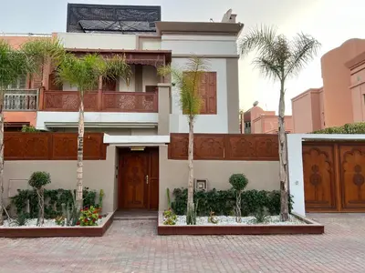 a house with palm trees in front of it at Dar Jacaranda in Marrakech