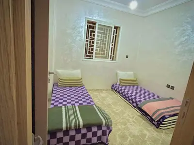 two beds in a room with purple and green at View Marrakech Apartment in Marrakech