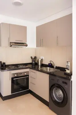 a kitchen with a washing machine and a sink at Ground floor 2 elegant bedrooms with direct pool access in Marrakech