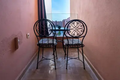 two chairs sitting next to a table in a window at Marrakech Calm Getaway 2 Pools & City Access in Marrakech