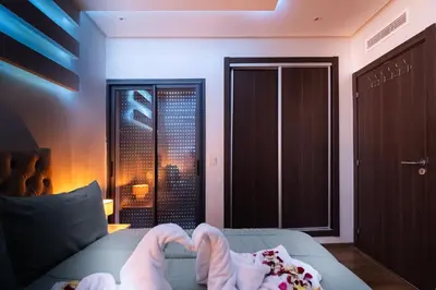 a person with their feet up on a bed with a window at Marrakech Calm Getaway 2 Pools & City Access in Marrakech