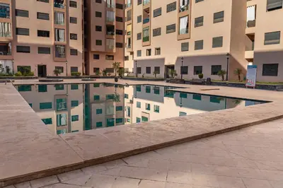 a pool in front of a building with reflections in it at Marrakech Calm Getaway 2 Pools & City Access in Marrakech