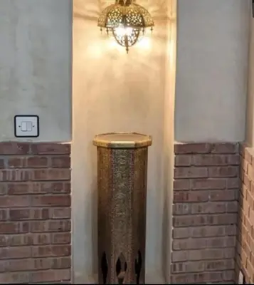a chandelier hanging from a wall next to a brick wall at Échappée onirique au cœur de la Cité Ocre in Marrakech