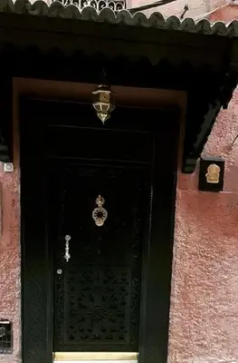a black door to a building with a sign on it at Échappée onirique au cœur de la Cité Ocre in Marrakech