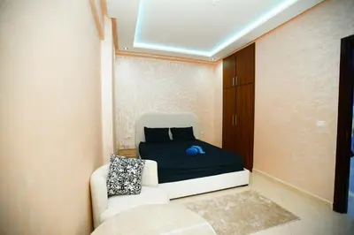 a small bedroom with a bed and a couch at New apartment rental in Marrakech