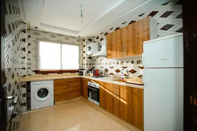 a kitchen with a white refrigerator and a washing machine at New apartment rental in Marrakech