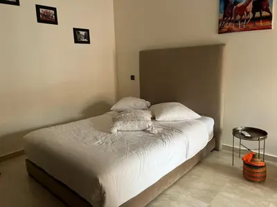 a bedroom with a bed with white sheets at Mimi MARRAKECH in Marrakech
