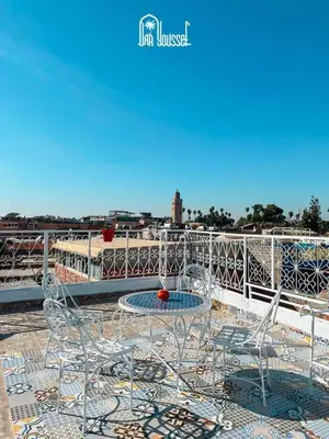 a table and chairs on top of a balcony at hostel Daryusssef114 in Marrakech