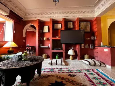 a living room with red walls and a flat screen tv at Dreams in Marrakech in Marrakech