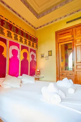 a bedroom with a large white bed with a red headboard at Condo in the Heart of the Palmeraie, Pools in Marrakech