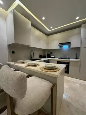 a kitchen with a large island with a counter top at Atlas-Si Cosy Appart Carré Eden in Marrakech