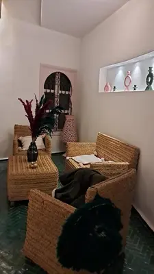 a living room with wicker chairs and a table at Riad Paillettes in Marrakech