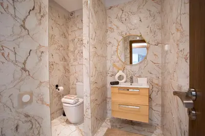 a bathroom with a toilet and a sink and a mirror at Luxueux appartement piscine coralia in Marrakech