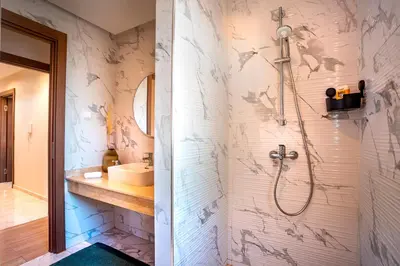 a bathroom with a shower and a sink at Luxueux appartement piscine coralia in Marrakech