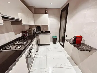 a kitchen with white cabinets and a stove top oven at Luxury Apt near Majorelle & City Center in Marrakech