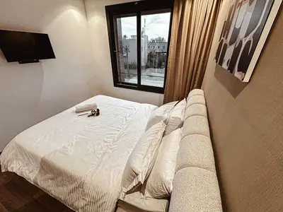 a bed in a room with a couch and a window at Luxury Apt near Majorelle & City Center in Marrakech