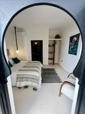 a bedroom with a bed and a large arched doorway at Riad Muvira in Marrakech