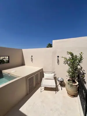 a balcony with a chair and a swimming pool at Riad Muvira in Marrakech