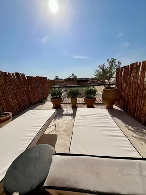 a row of beds on a patio with a fence at Riad Muvira in Marrakech